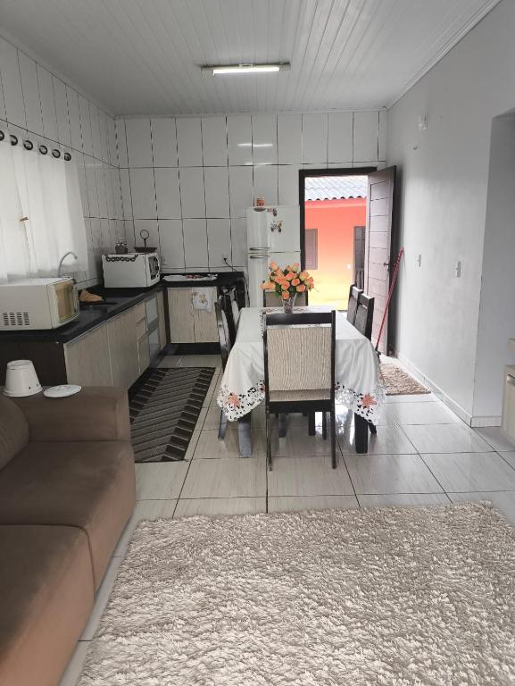 a kitchen with a table and chairs in a room at Paraíso chama in Jaguaruna