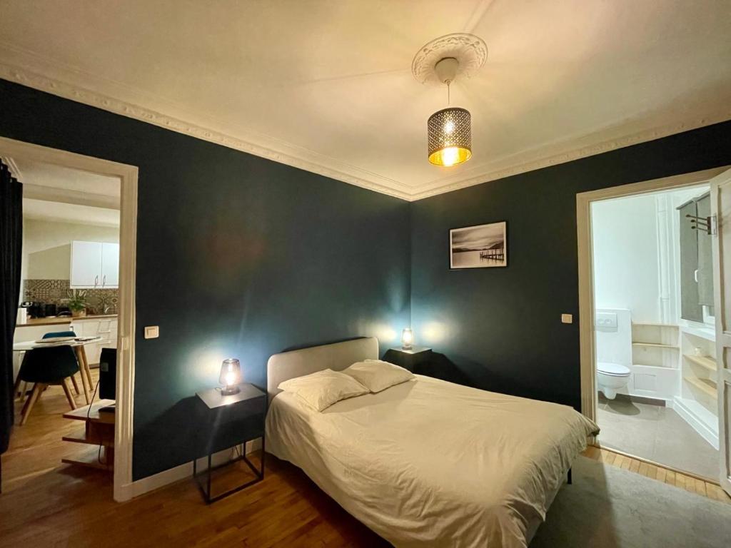 a bedroom with a bed and a blue wall at Appartement Porte de Versailles Olivier de Serre in Paris