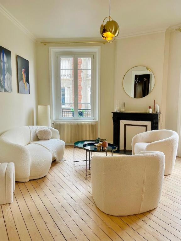Elle comprend un salon doté d'un mobilier blanc et d'une cheminée. dans l'établissement Appartement terrasse vue cathédrale centre ville, à Reims