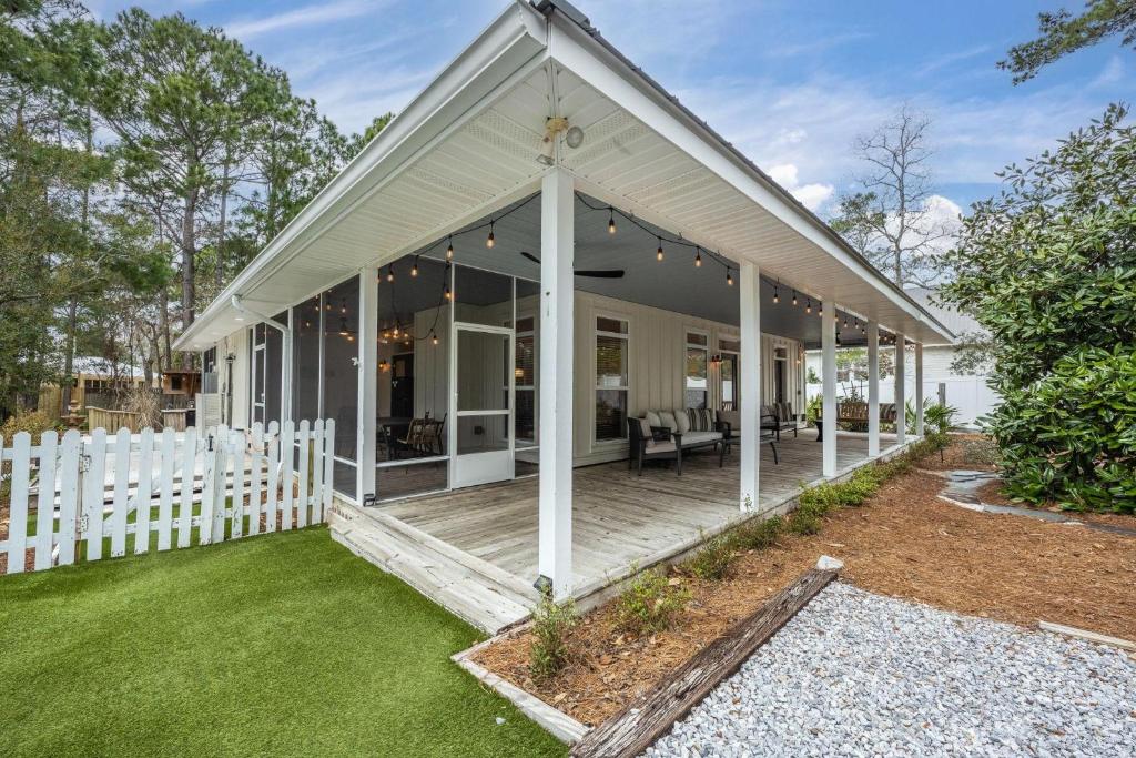 una casa con una cerca blanca y un porche en Restful Ridge, en Santa Rosa Beach