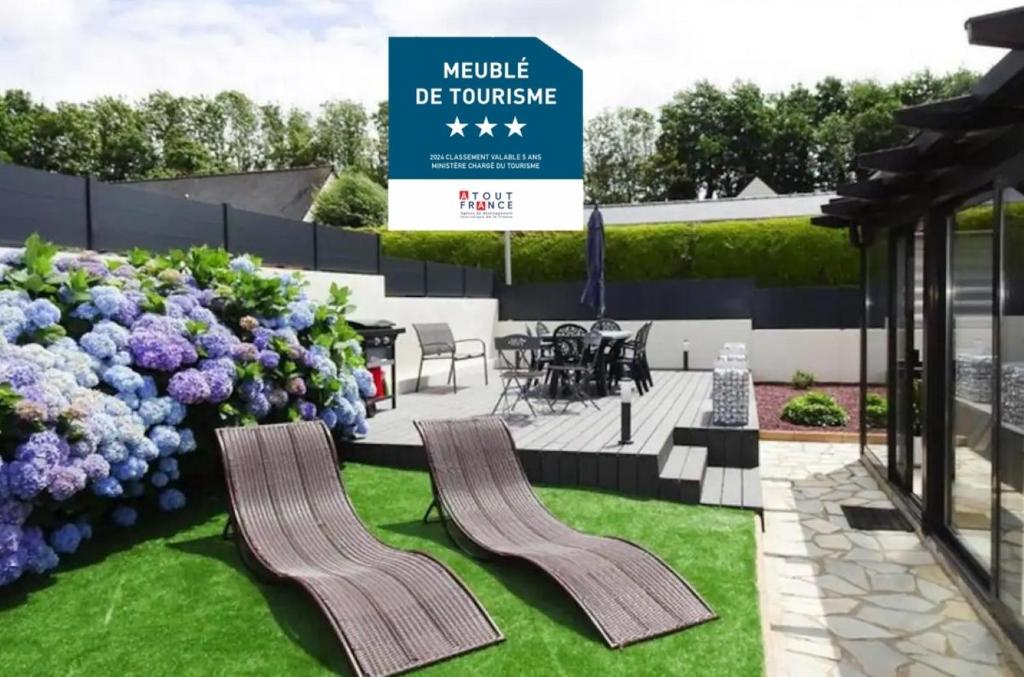 ein Schild vor einem Garten mit lila Blumen in der Unterkunft Maison familiale - Côte de Granit Rose in Saint-Quay-Perros