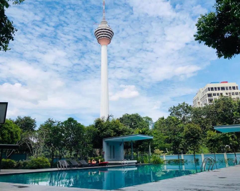 einen Blick auf den Space Needle Tower vom Pool in der Unterkunft Suasana Bukit Ceylon KLCC by SwiftTravels in Kuala Lumpur