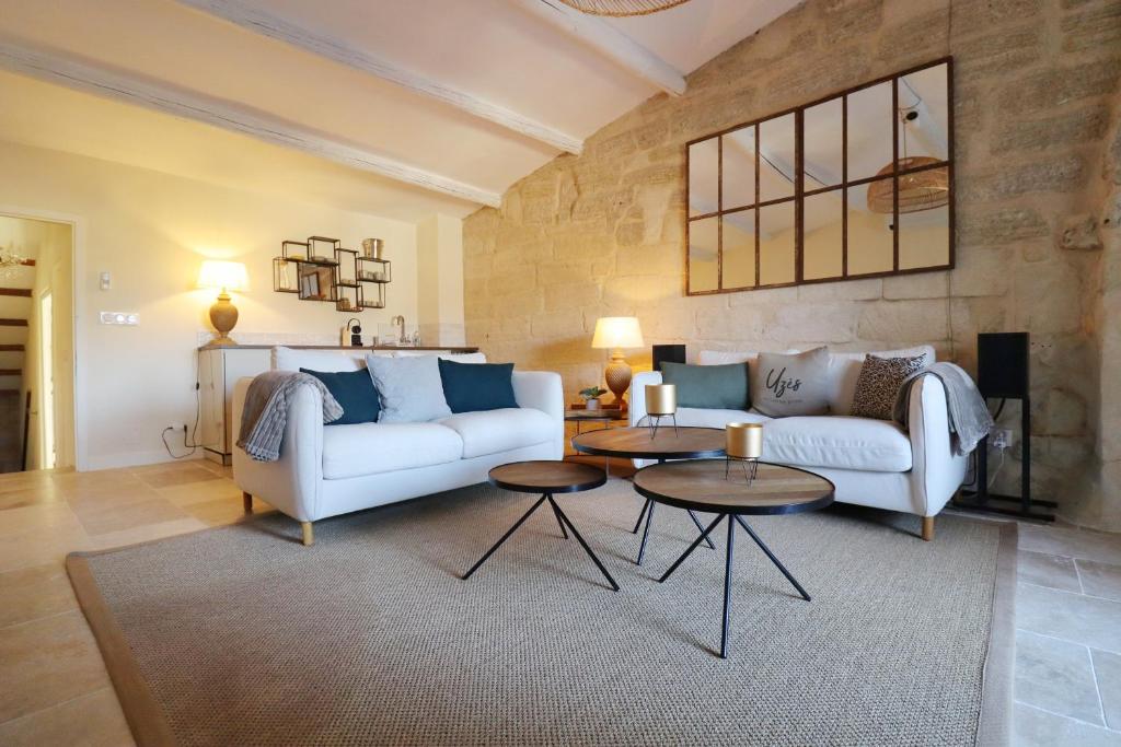 - un salon avec un canapé blanc et 2 tables dans l'établissement La Grande Bourgade-Authentique Maison en Pierre avec Terrasse Climatisation au Cœur d'Uzès, à Uzès
