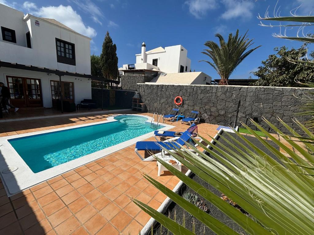 basen z leżakami obok domu w obiekcie Villa Adel 56, private heated pool, parking w mieście Playa Blanca