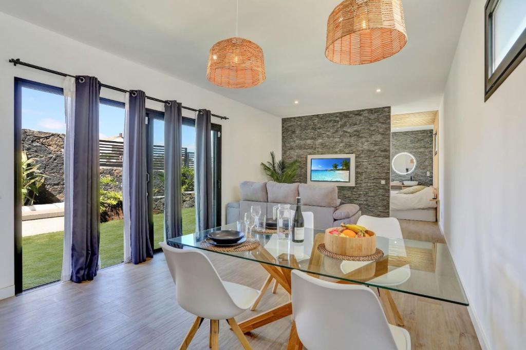 a dining room with a glass table and chairs at ISLAND WEEK Fuerteventura in La Oliva