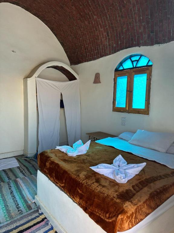 a bedroom with a bed with two towels on it at Nubian King in Aswan