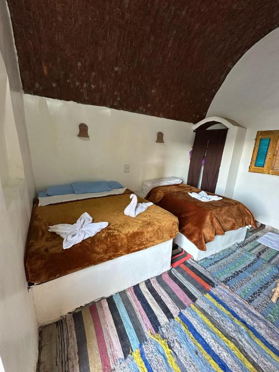 two beds with white birds on them in a room at Nubian King in Aswan