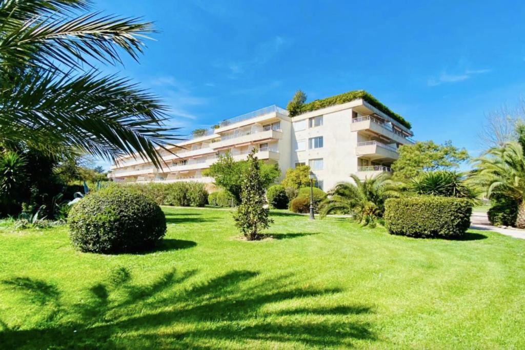 un grand bâtiment avec une cour plantée d'arbres et de buissons dans l'établissement Beautiful Studio with shared pool, à Saint-Tropez