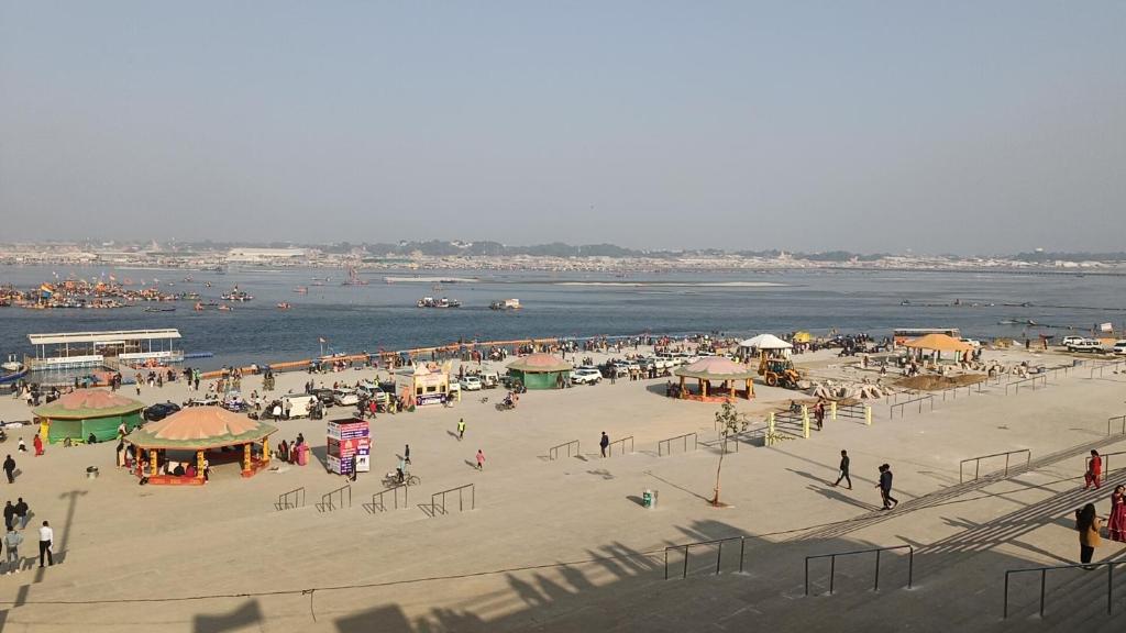 a group of people on a beach near the water at Shashi Bhawan in Prayagraj