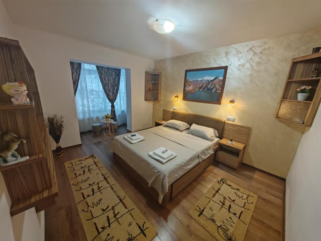 un dormitorio con una cama grande en una habitación en Apartament Luca, en Călimăneşti