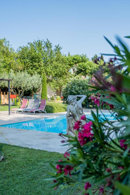 - une piscine entourée de chaises et de fleurs dans la cour dans l'établissement Mas des Agranas, à Sénas