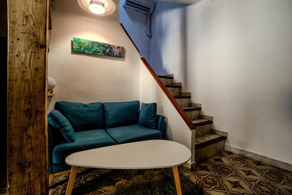 un salon avec un canapé bleu et une table dans l'établissement Maison de village au coeur de CANET en ROUSSILLON, à Canet