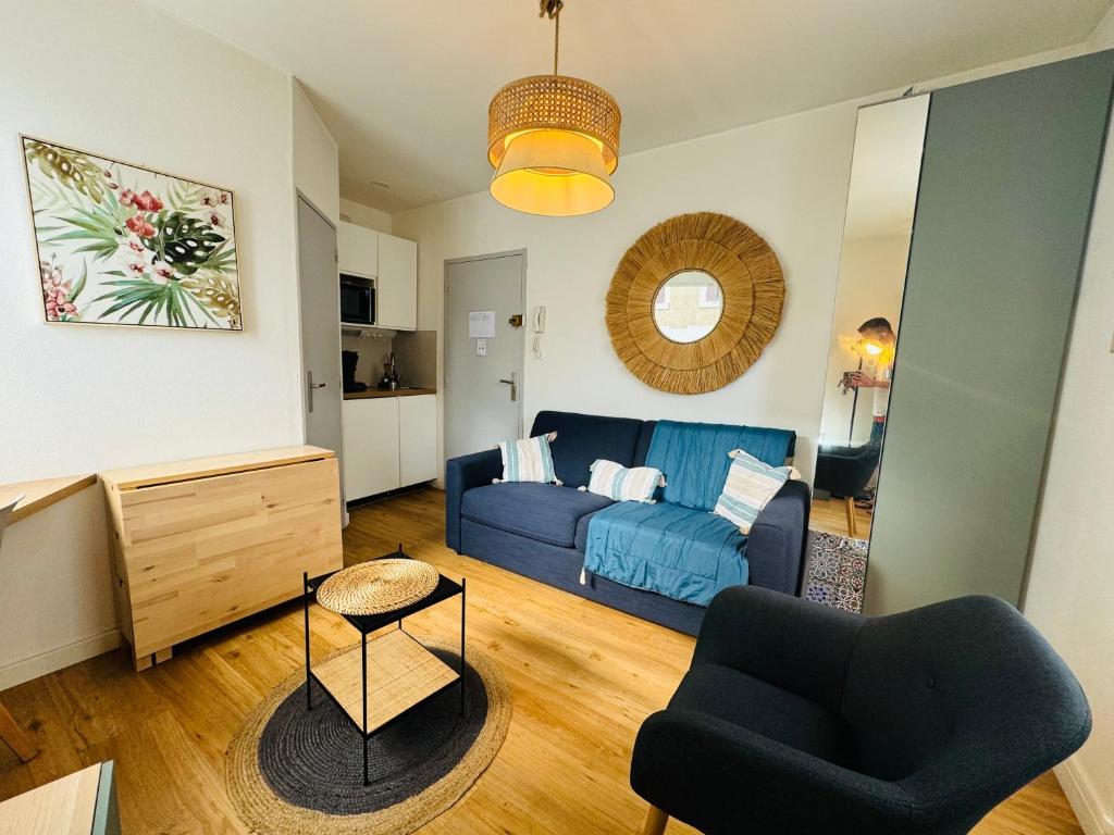 un salon avec un canapé bleu et une chaise dans l'établissement Le Studio Cosy, à Périgueux