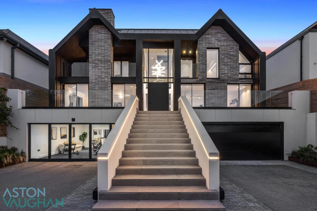 a home with a staircase leading to the front door at Luxe Retreat 5-Bedroom Designer Home Pool & Cinema in Brighton & Hove