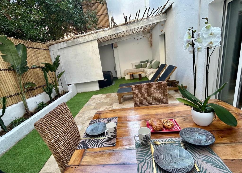 un patio avec une table et des chaises sur un patio dans l'établissement Cœur cannois avec terrasse, clim et jacuzzi, à Cannes