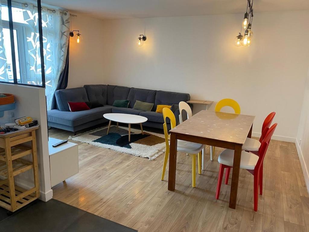 un salon avec un canapé, une table et des chaises dans l'établissement Bel et moderne appartement à 15 min de Paris, à Houilles