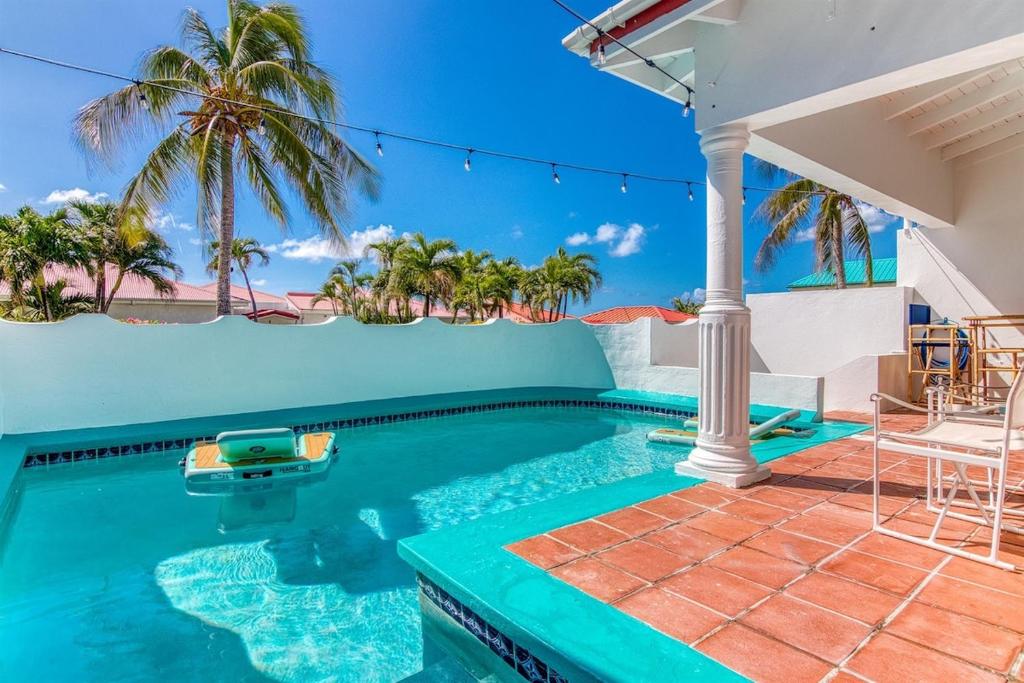 a swimming pool in a house with palm trees at Charming 3BR Villa w Private Pool in Pelican Key in Simpson Bay