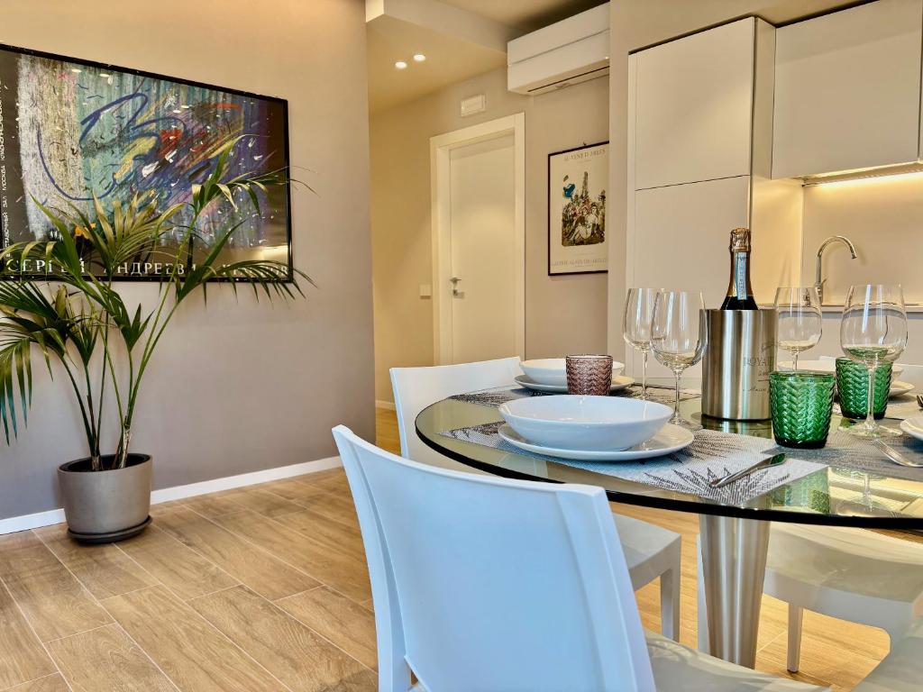een eetkamer met een tafel en witte stoelen bij Appartamenti BETTELONI in Bardolino