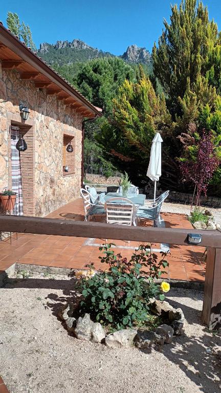a patio with a table and chairs and an umbrella at Casa Maite in Riópar