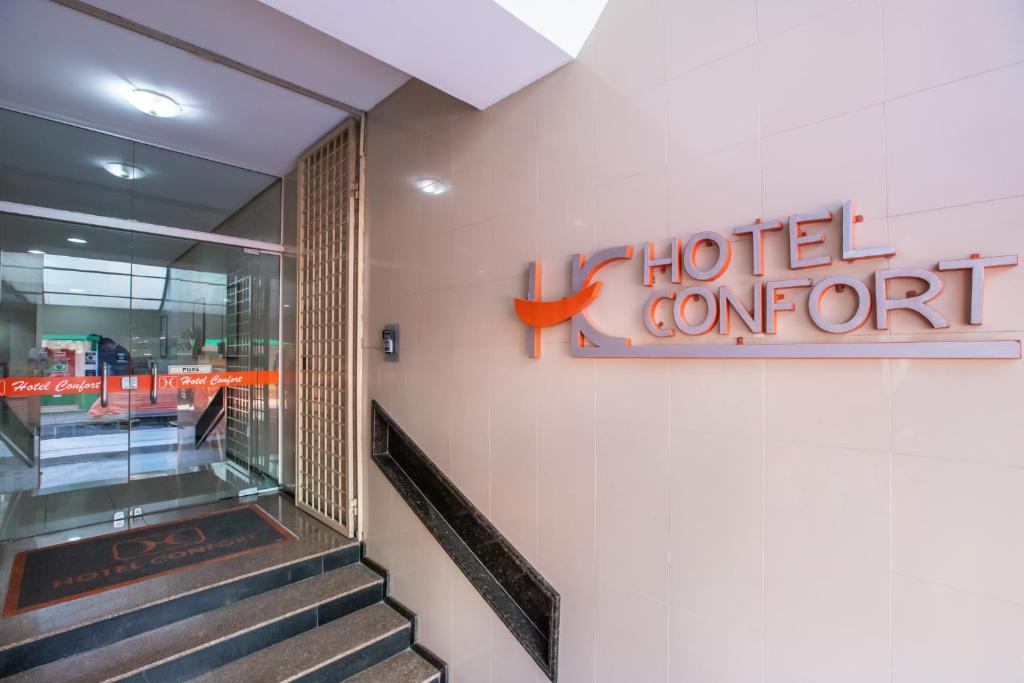 a hotel sign on a wall next to a staircase at Hotel Express Confort in São Leopoldo