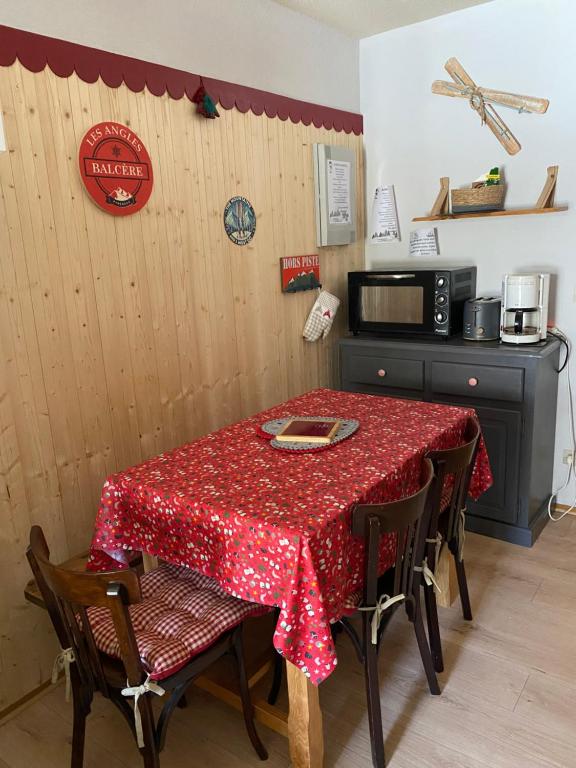 kuchnia ze stołem z czerwoną tkaniną w obiekcie Charmant appartement avec parking privé dans une petite résidence très calme w mieście Les Angles