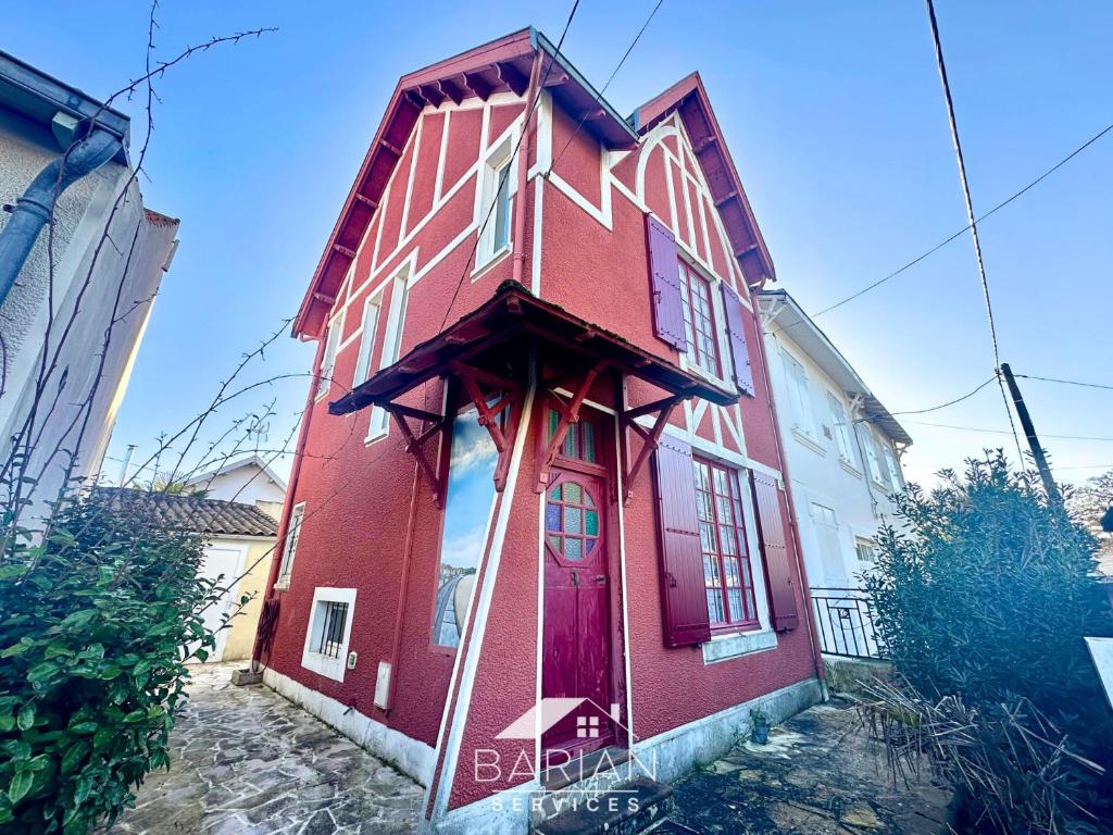 a red and white building with a red door at Bord de mer 60 m - Charmante Maison 5 personnes in Fouras