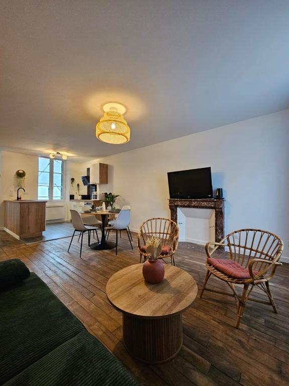 un salon avec une table et des chaises et une cheminée dans l'établissement L'authentique - Appartement 4, à Loudéac