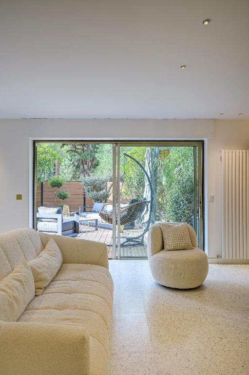 un grand salon avec un canapé et une terrasse dans l'établissement Perle rare au coeur de la pinede, à Antibes