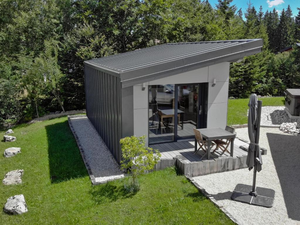 un petit hangar avec banc dans une cour dans l'établissement Cottage contemporain Cosy & Chic, à Prémanon