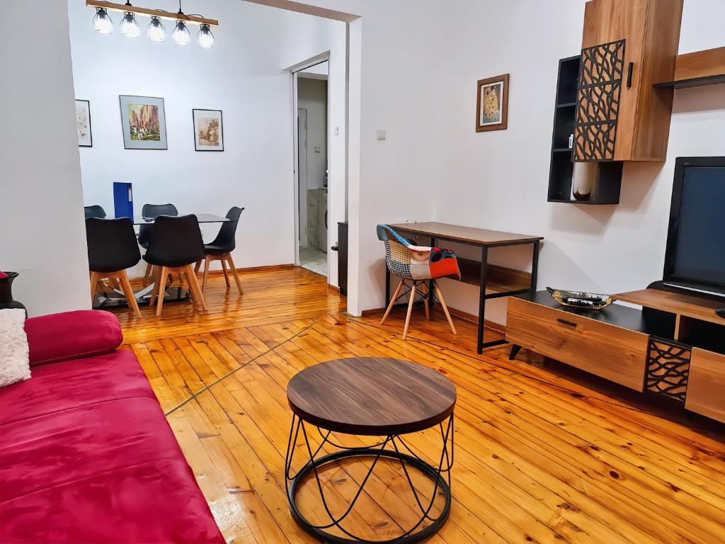 a living room with a tv and a table and chairs at Family Apartment next to National Palace of Culture in Sofia