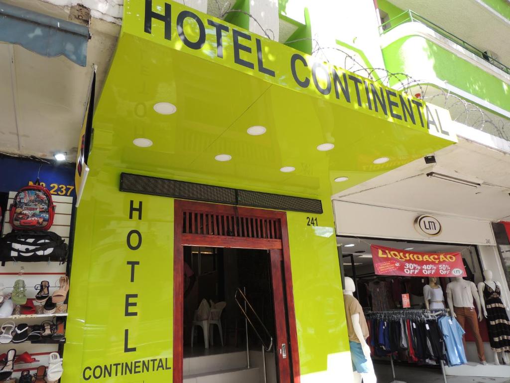 a hotel entrance with a yellow sign above a door at Hotel Continental - Próximo ao Mercado Central, Mercado Novo e a Rodoviária in Belo Horizonte