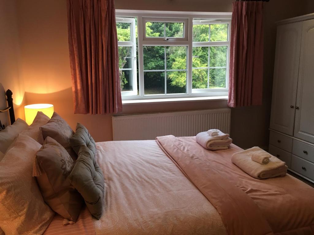 a bedroom with a bed with two towels on it at Leafy Suburban Bed and Breakfast in Northwood