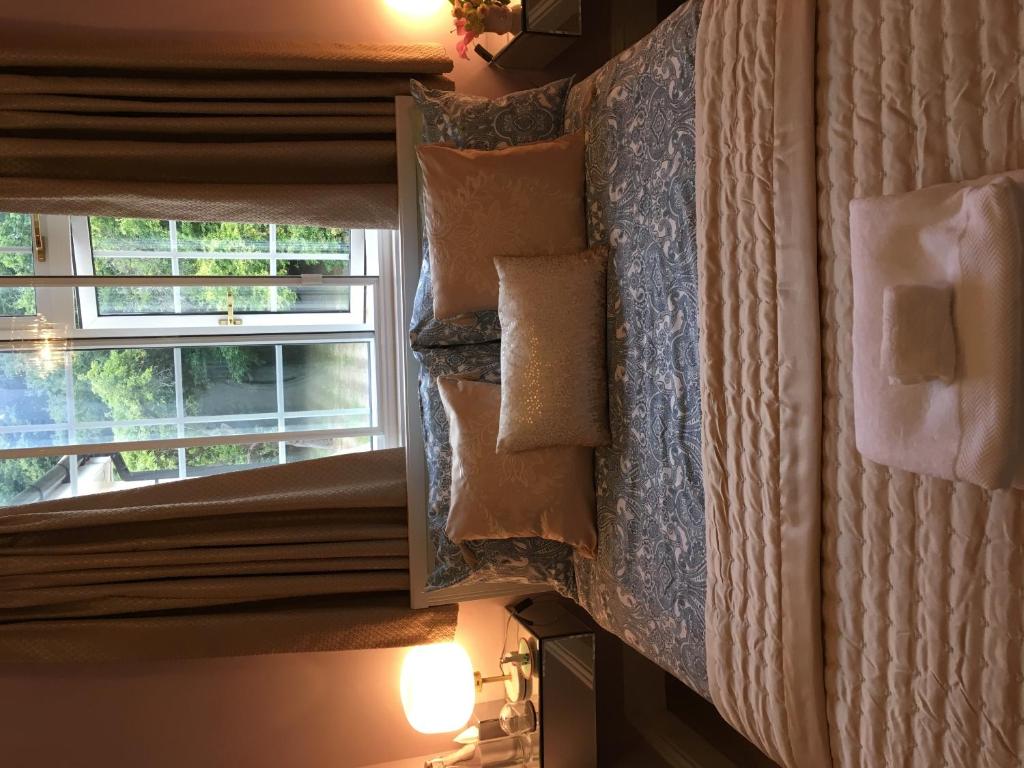 a room with a window and pillows on a wall at Leafy Suburban Bed and Breakfast in Northwood