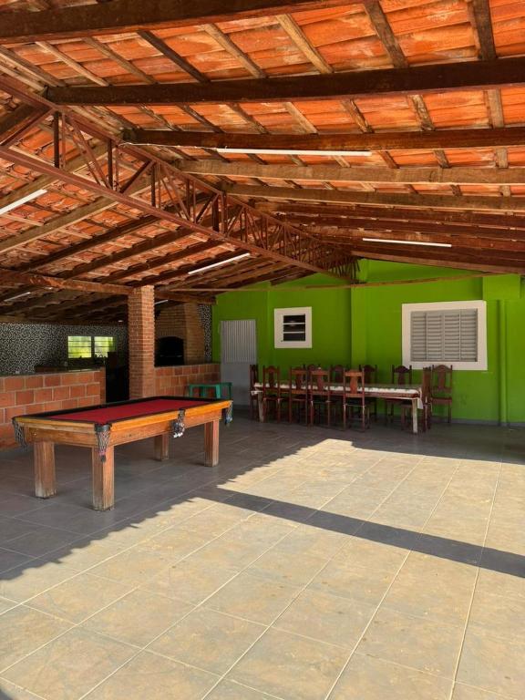 a room with a ping pong table and a green wall at Chácara Leão Dourado in Pôrto Feliz
