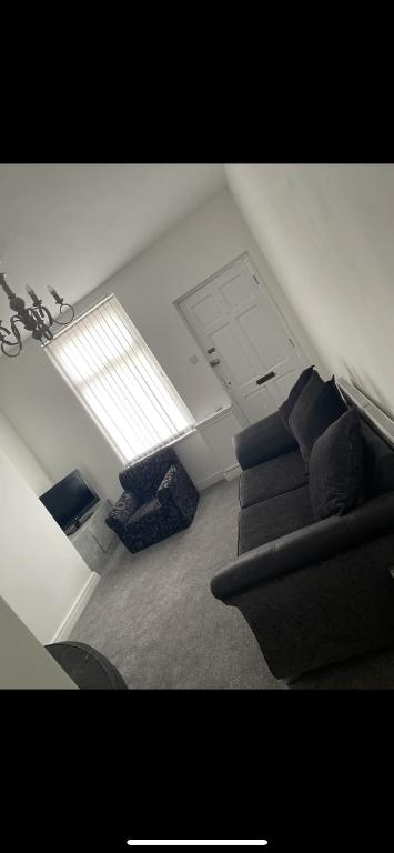 a living room with a couch and a chair at Denton House in Manchester