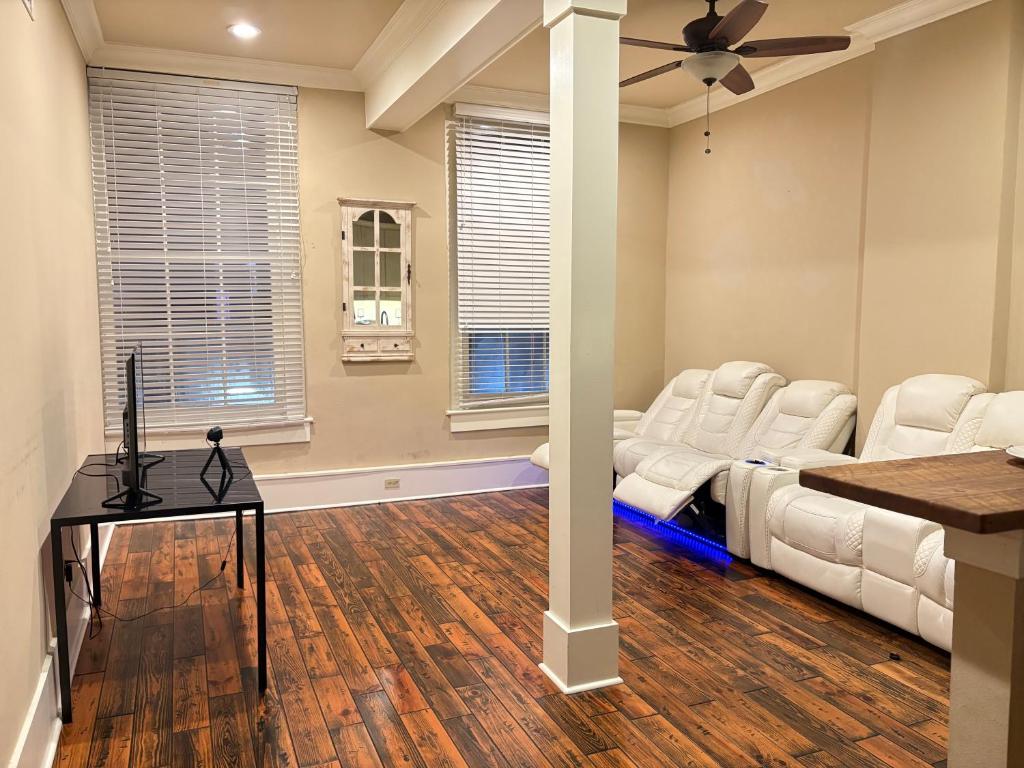 een woonkamer met witte meubels en een plafondventilator bij 305 Decatur st in New Orleans