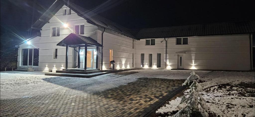 a large white building with a gazebo at night at Casa Adam B in Gara Ilişeşti