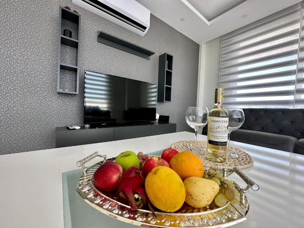 a bowl of fruit on a table with a bottle of wine at ARCADIA Homes in Alanya