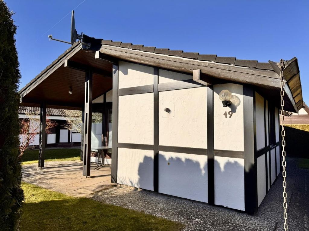 a small white garage with a goat in it at Freistehender Ferienbungalow im Fachwerkstil in Burhave