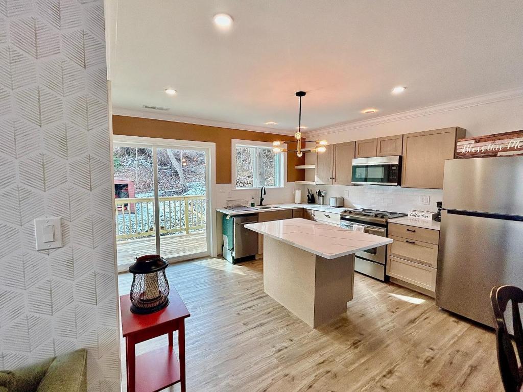 a kitchen with a stainless steel refrigerator and wooden floors at 2 Bedroom Apartment in SONO! in Norwalk