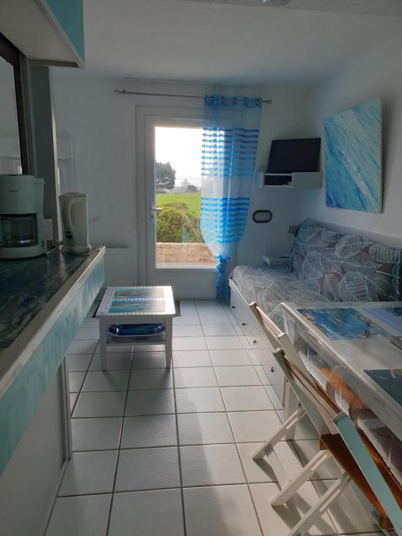 un soggiorno con un divano e un tavolo di Vue sur mer 300m de la plage ad Arzon