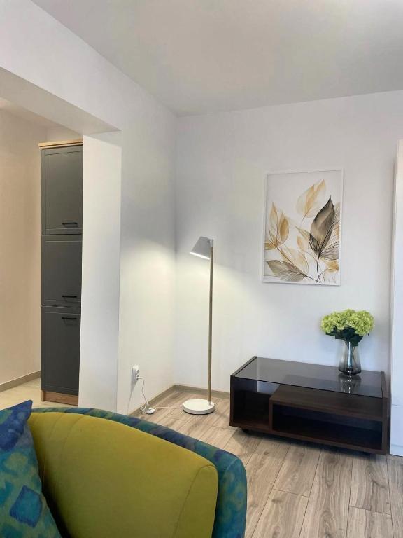 a living room with a green couch and a table at Apartament Corvin 1 in Hunedoara