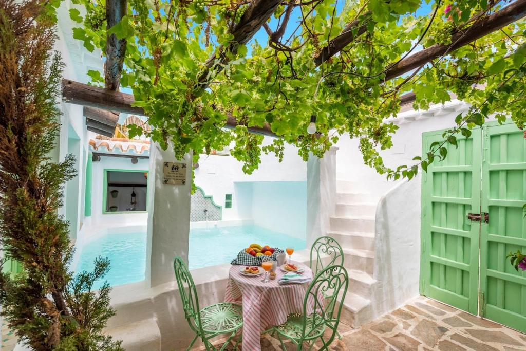 a table and chairs on a patio next to a pool at Casa Spa de la Mariola in La Puebla de los Infantes