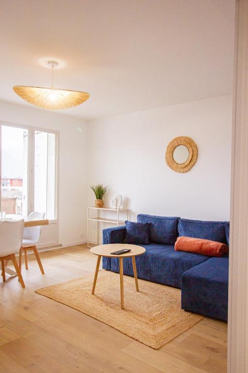 un salon avec un canapé bleu et une table dans l'établissement Le Mirat - Private & Balcon, à Albertville