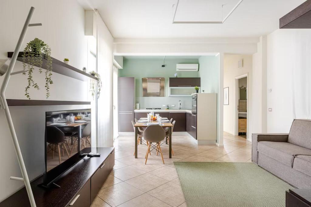 a living room and kitchen with a table and a couch at Appartamento Louis in Verona