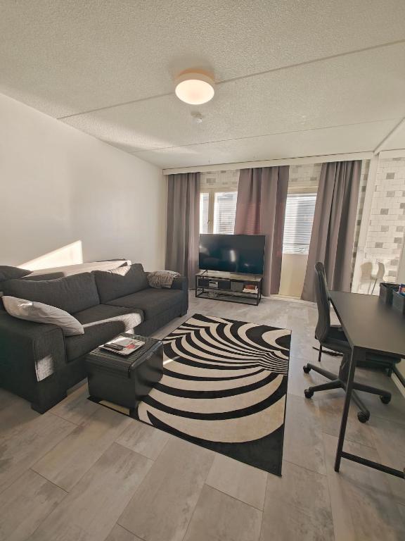 un soggiorno con un divano e un tavolo di Eerikinkadun Helmi a Salo