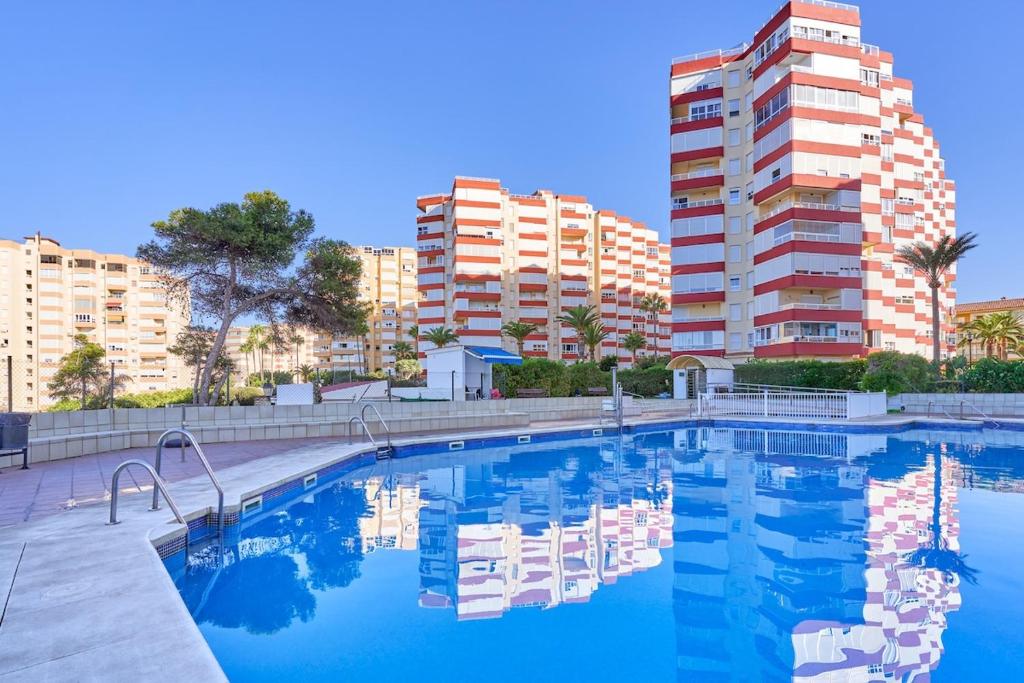 a large swimming pool with buildings in the background at Calm Bungalow in Torrox