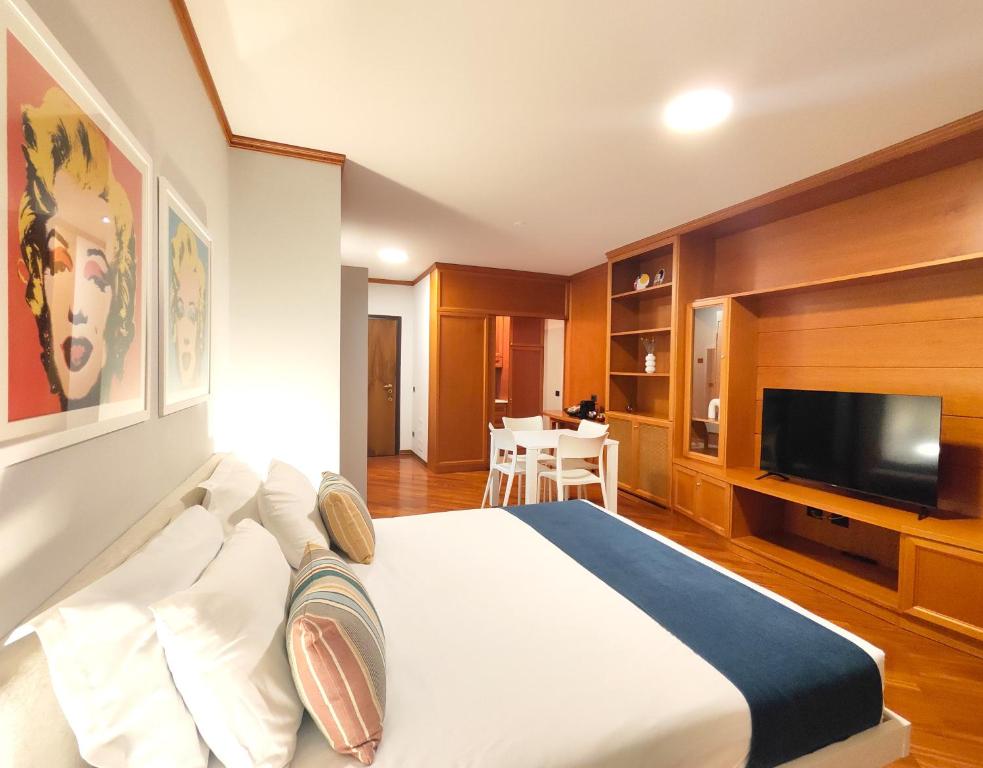 ein Hotelzimmer mit einem Bett und einem Flachbildfernseher in der Unterkunft Jasmine Golf & Malpensa, studio in Robinie club in Solbiate Olona