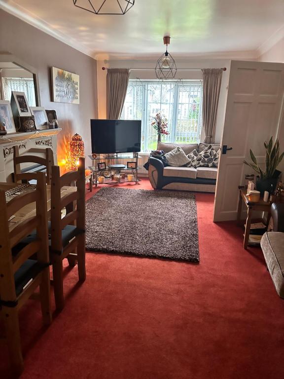 a living room with a couch and a television at A beautiful tranquil home in Birmingham