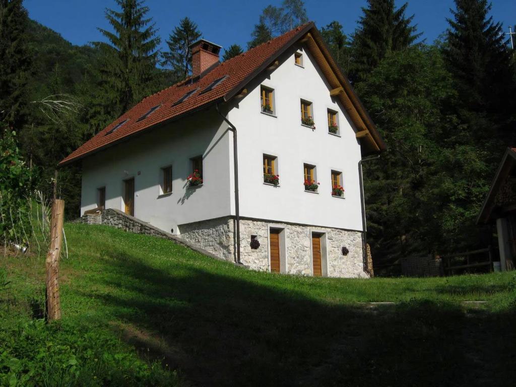 ein weißes Haus mit einem roten Dach auf einem Hügel in der Unterkunft Ferienhaus für 8 Personen ca 189 m in Dolenja Trebuša, Küstenland Slowenien in Dolenja Trebuša